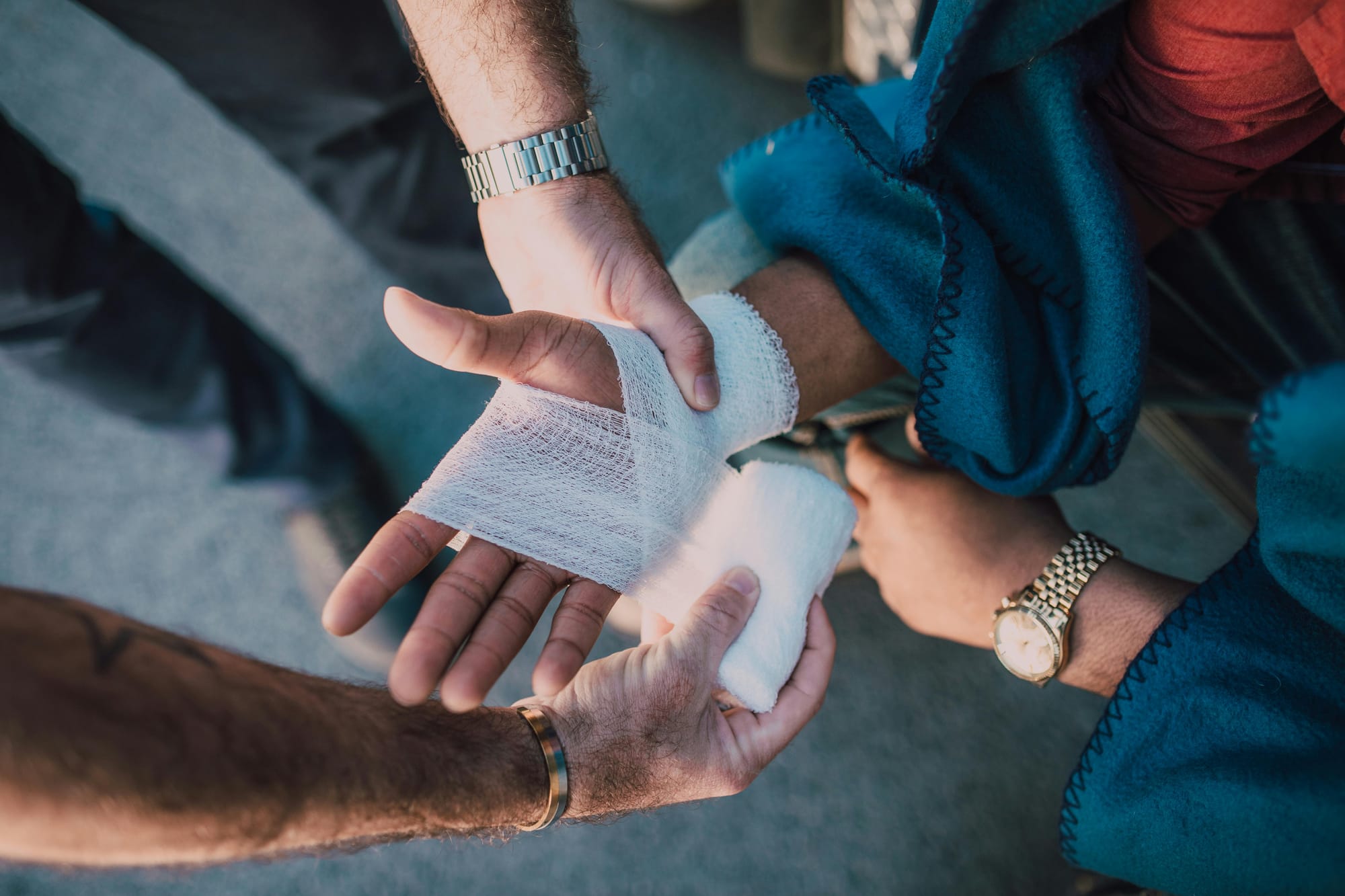 Person with a bandaged hand receiving first aid after a workplace injury