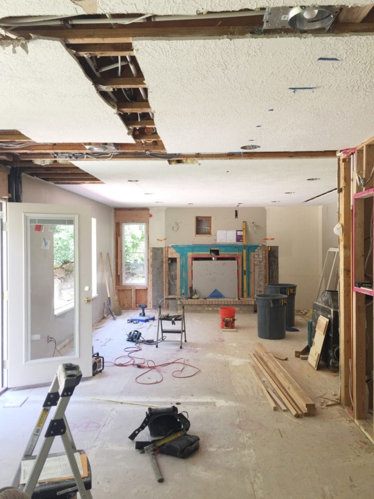 Living room under renovation with exposed beams and tools.